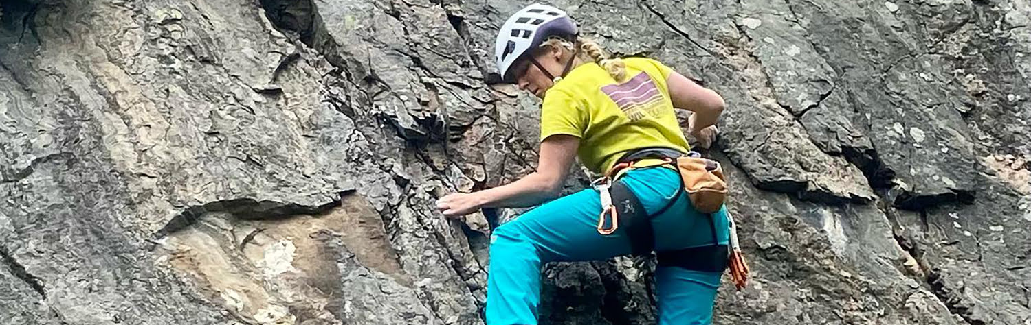 A woman climbing up a rock face.