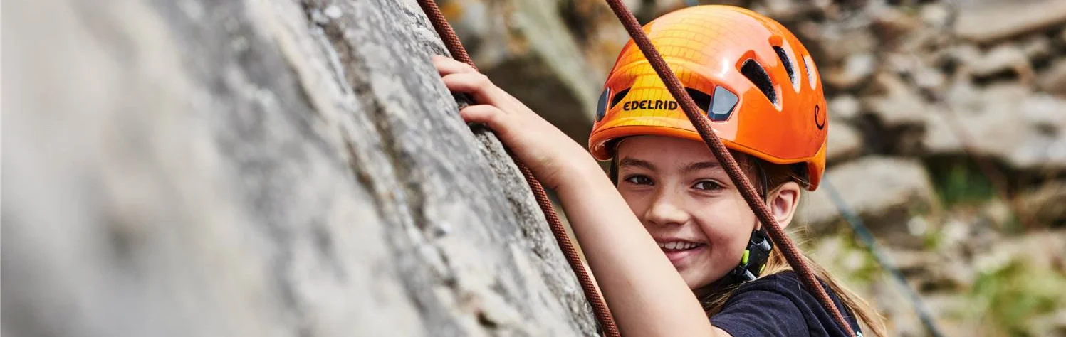 RealRock - Roped Taster 7 Young girl wearing a helmet while rock climbing